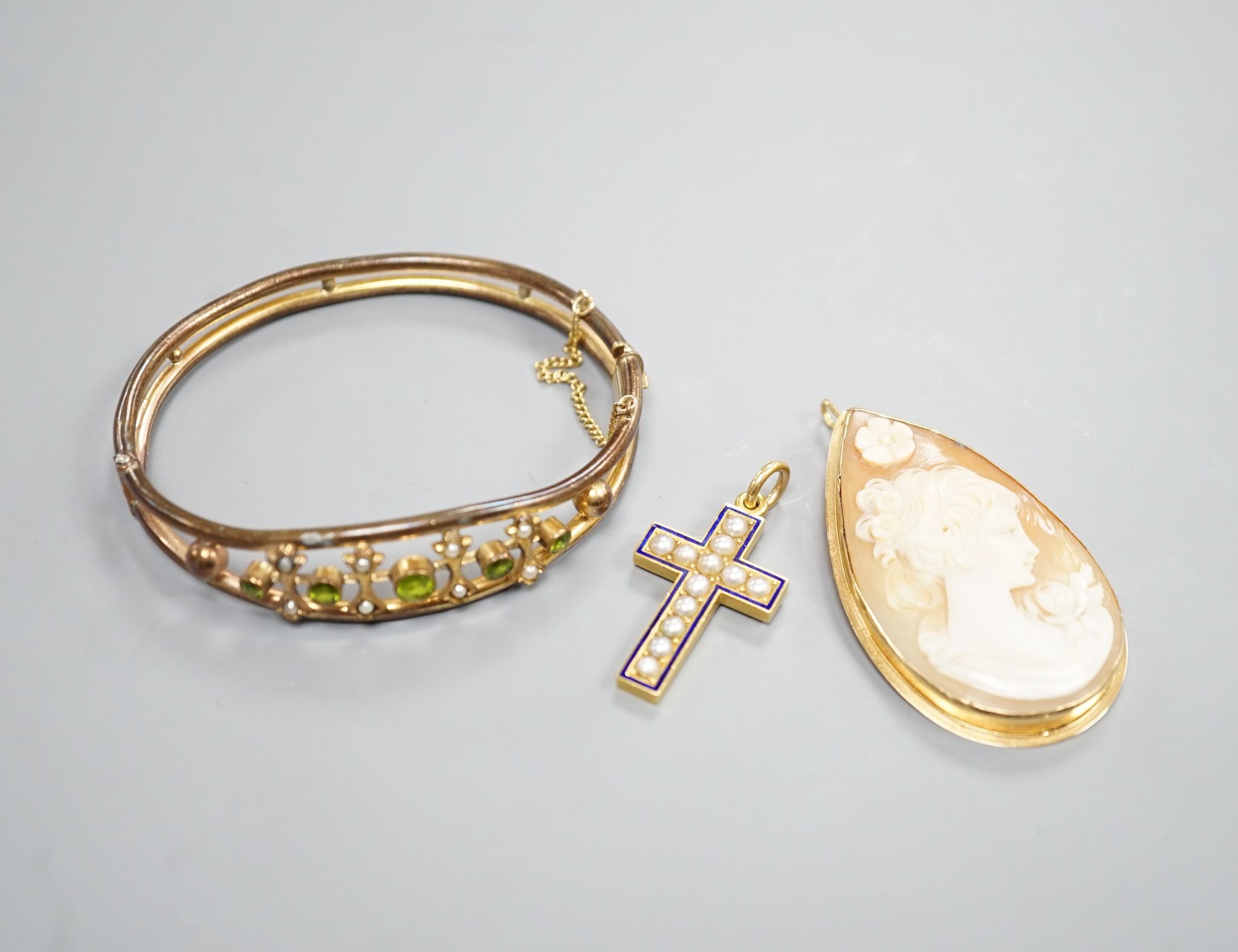 A modern 750 mounted oval cameo shell brooch, 52mm, a yellow metal, split pearl and enamel cross pendant and a paste set gilt metal bangles.